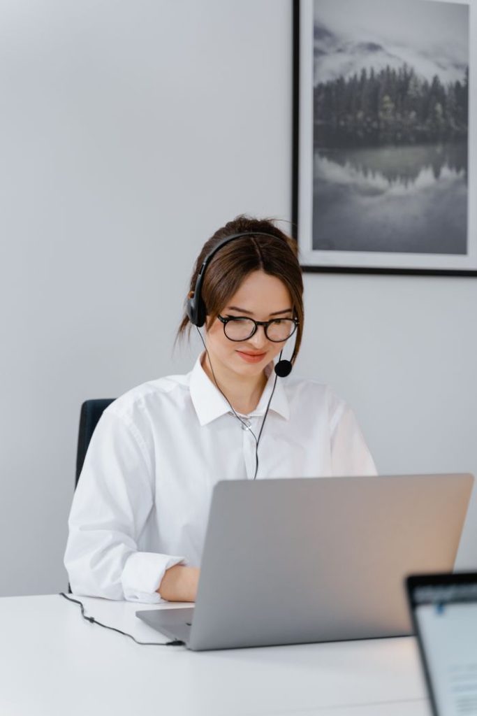 pexels photo 7709272 7709272 Professional woman providing customer support using a laptop and headset in a modern office.